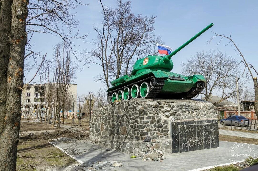 Танк у Волновасі з російським прапором на тлі зруйнованого росіянами будинку
