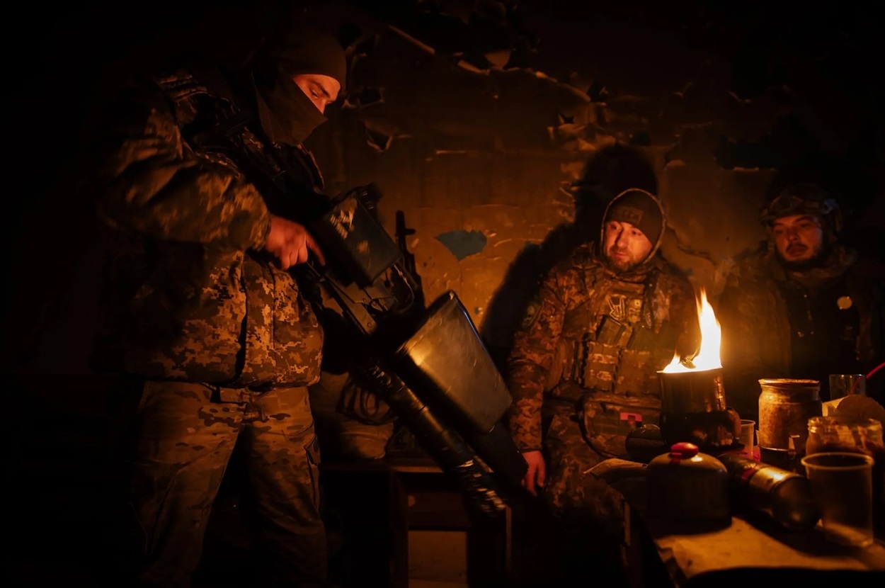Українські воїни біля окопної свічки