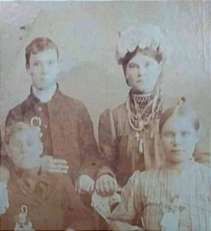 На жінці намисто дрібний корал і баламути з трьома хрестиками та прикраса навколо шиї чокер з дрібними дукатами