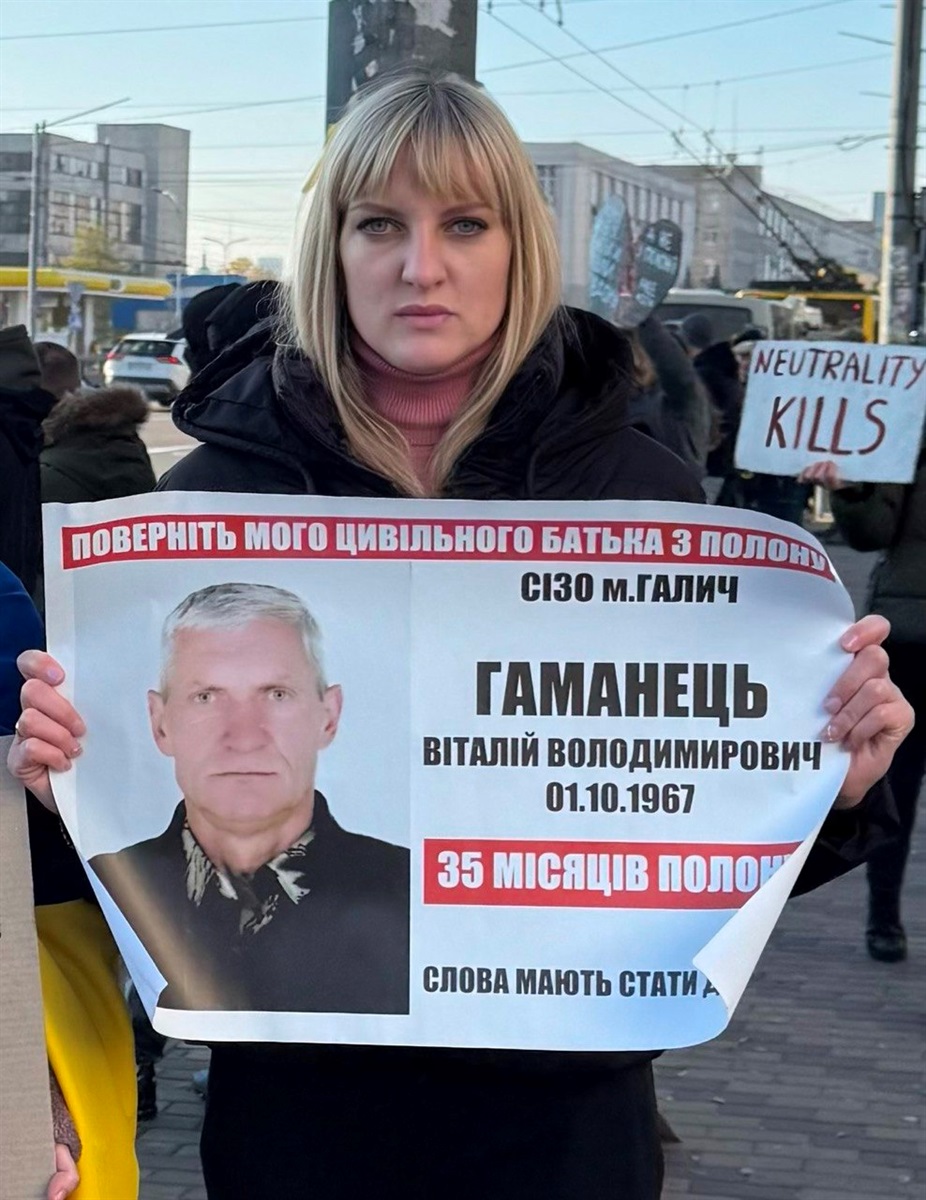 Катерина Кас’янова з плакатом з фотографією батька