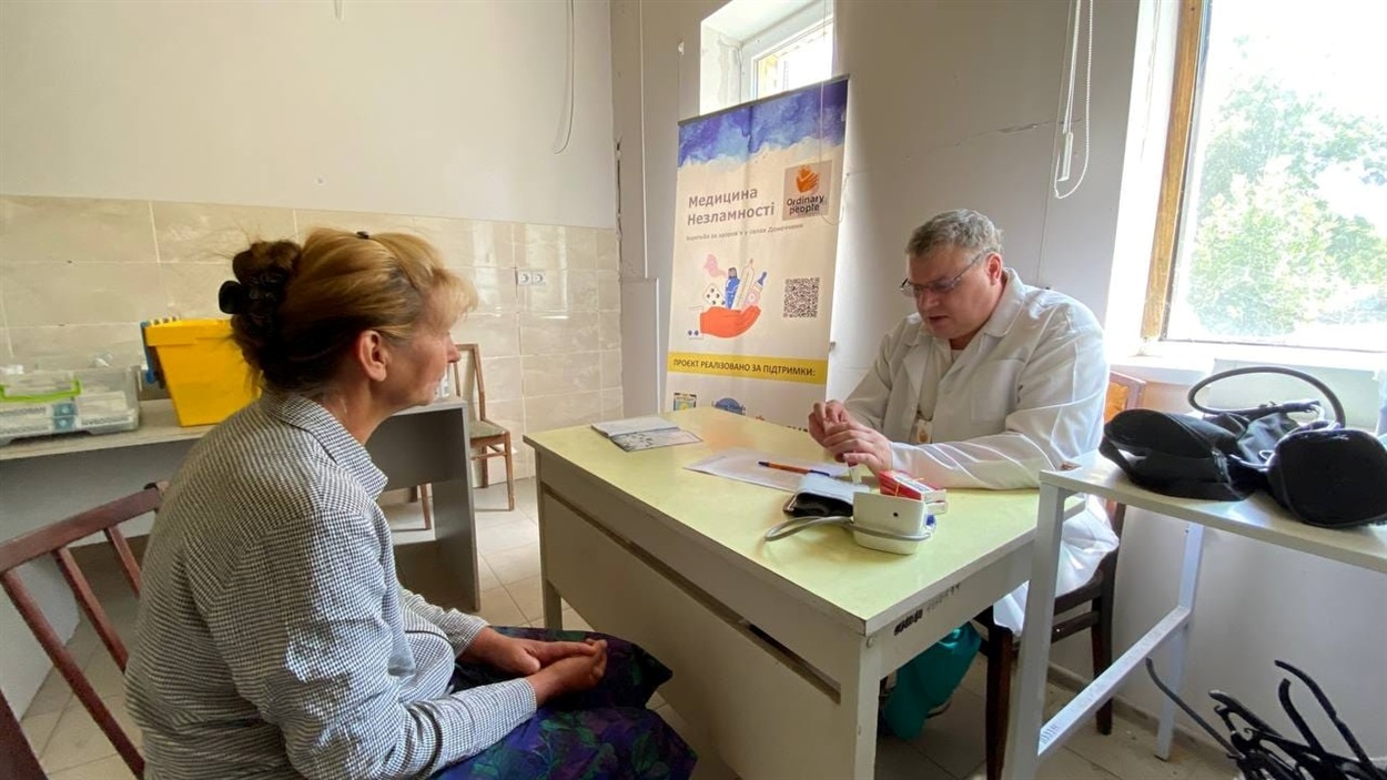 Volunteer doctor Vladyslav Khymenko with a patient in Volnovakha district