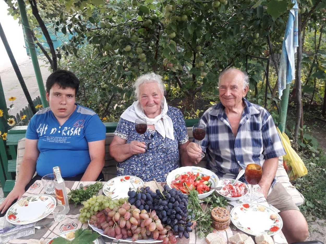 Георгій Поляков з дружиною та онуком у дворі свого будинку у Волновасі